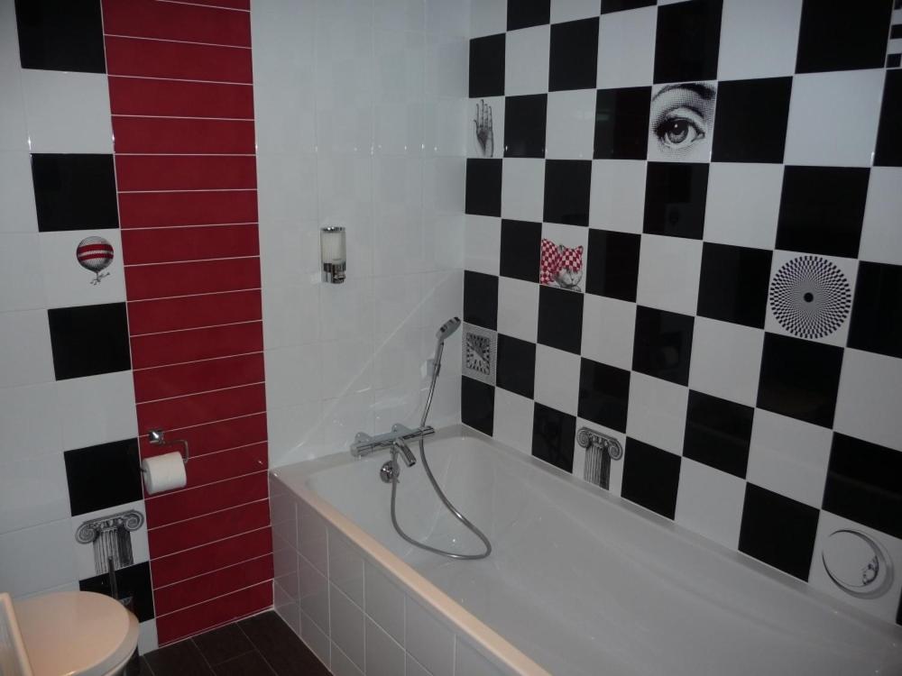 a bathroom with a black and white checkered wall at Hôtel Spunta Di Mare in Ajaccio