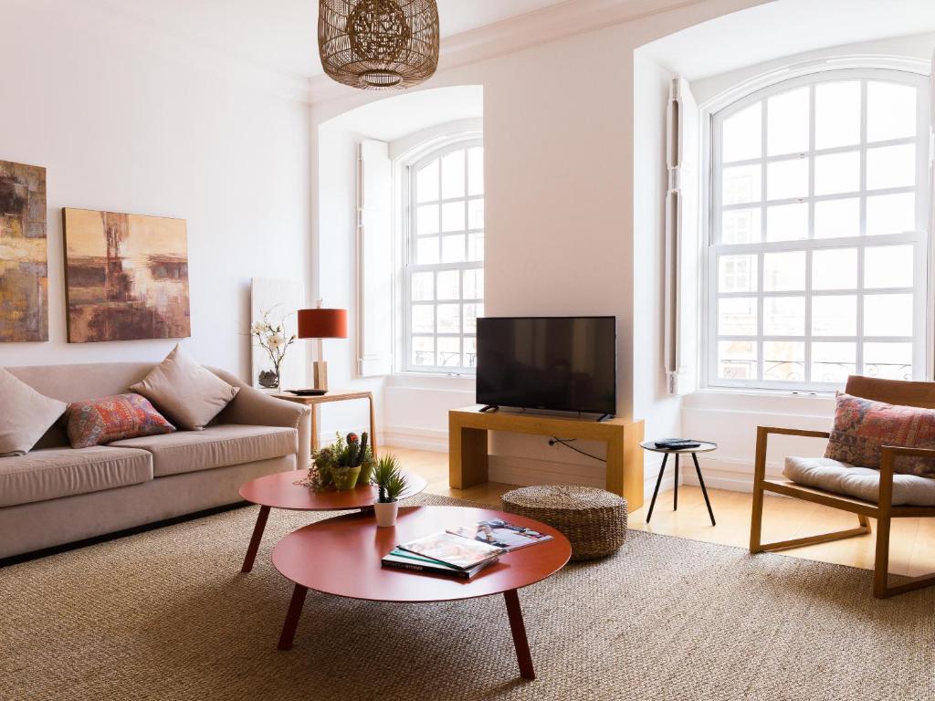 a living room with a couch and a tv at Chiado Spacious and Luxurious by Courtesy Morning in Lisbon
