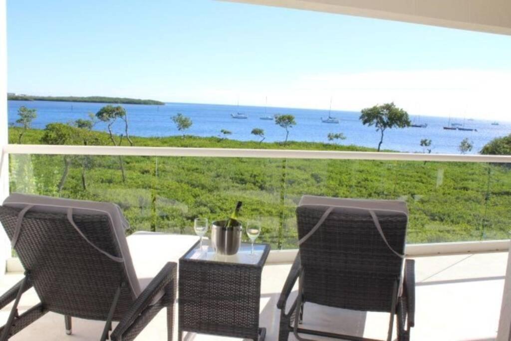 a balcony with a table and chairs and a view of the ocean at LICENSED MGR - LUXURIOUS OCEANFRONT CONDO W/STUNNING VIEWS - UPSCALE OCEANFRONT RESORT! in Key Largo