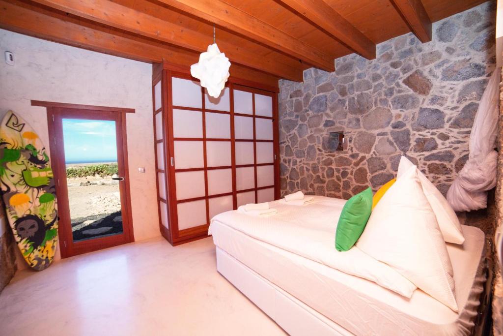 a bedroom with a bed with a stone wall at La Molina NK in Tindaya