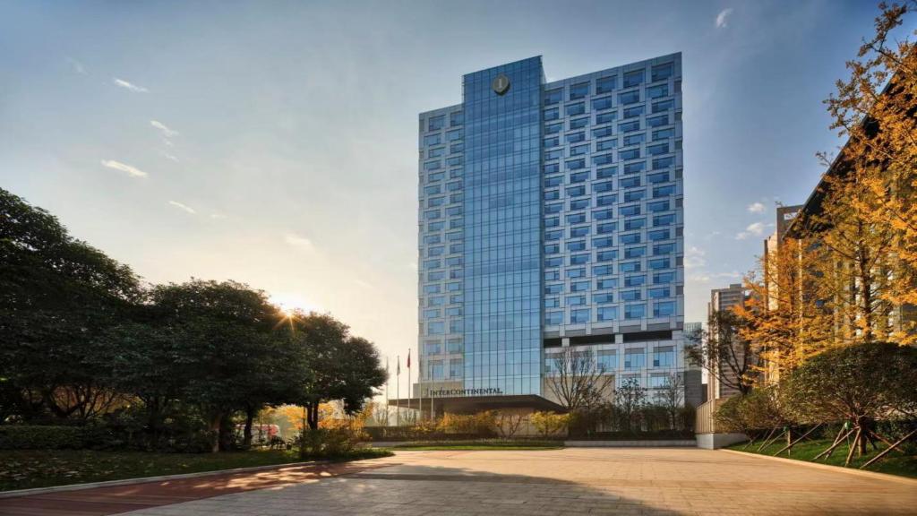 un edificio de cristal alto con un reloj. en InterContinental Xi'an North, an IHG Hotel en Xi'an