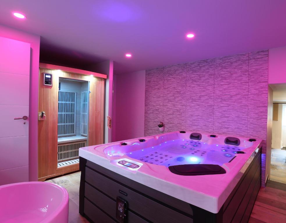 Habitación con baño rosa con bañera. en L'Escale Dinard en Tréméreuc