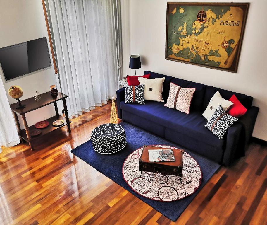 a living room with a blue couch and a table at Ricordi di Viaggio, maison retrò in Trieste