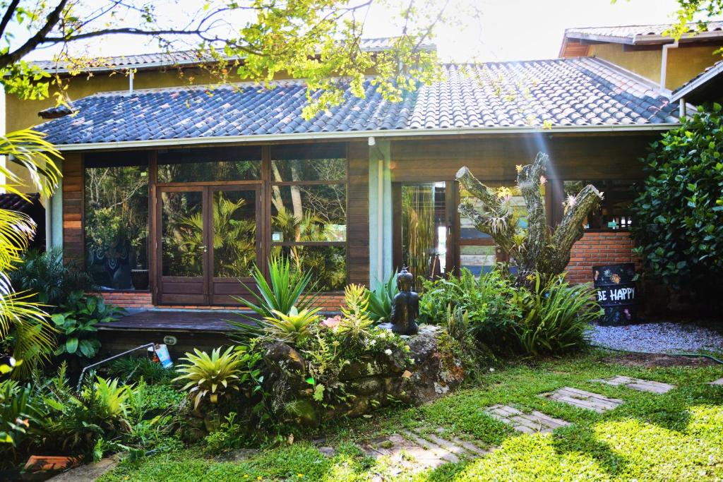 Pousada Alma da Gamboa في غامبوا: منزل صغير وامامه حديقة