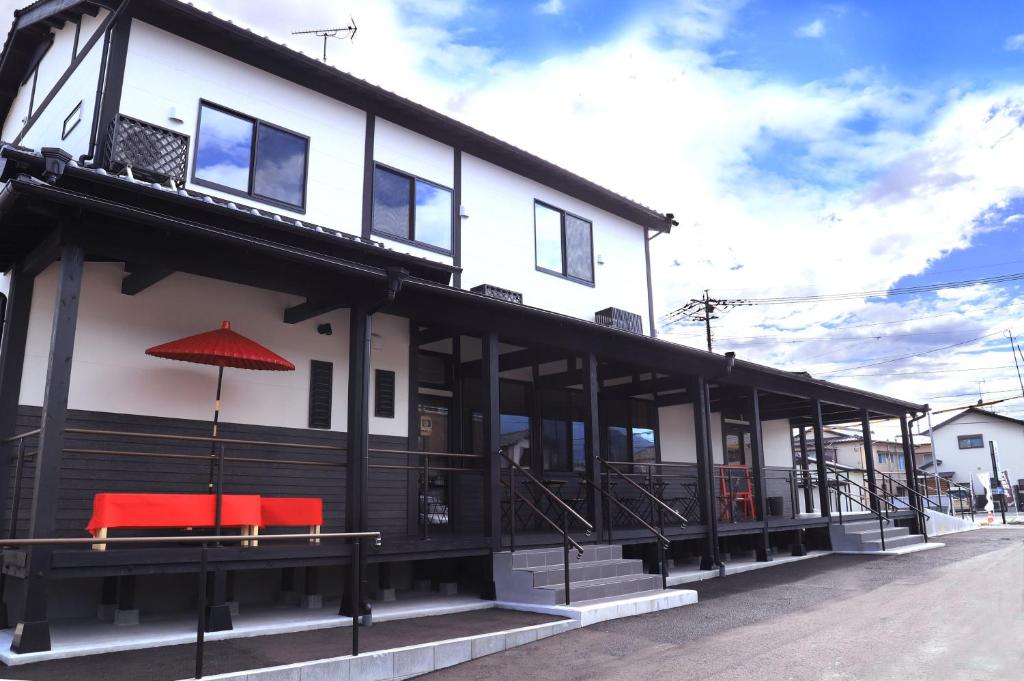 a building with a red umbrella on top of it at BASE ogi House of Sakuraoka in Ogi