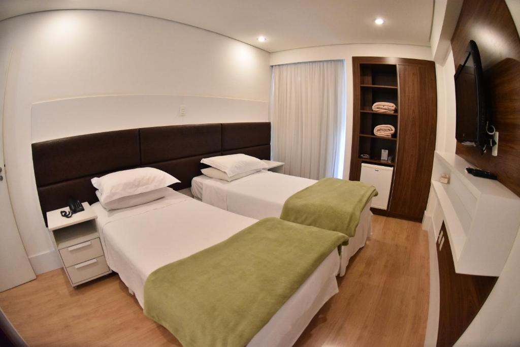 pokój hotelowy z 2 łóżkami i telewizorem w obiekcie Cordilheira Hotel w mieście Serra Negra