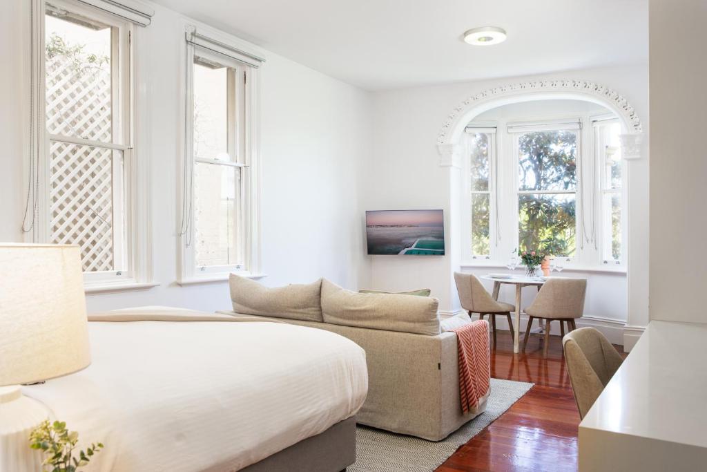 sypialnia z łóżkiem, kanapą i stołem w obiekcie Ravenscourt’s Studio Apartment Close to Everything w mieście Sydney