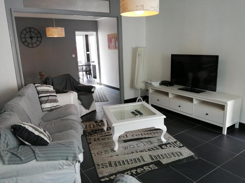 un salon avec un canapé et une télévision dans l'établissement Maison de vacances au cœur des Sables d’Olonne, à Les Sables-dʼOlonne