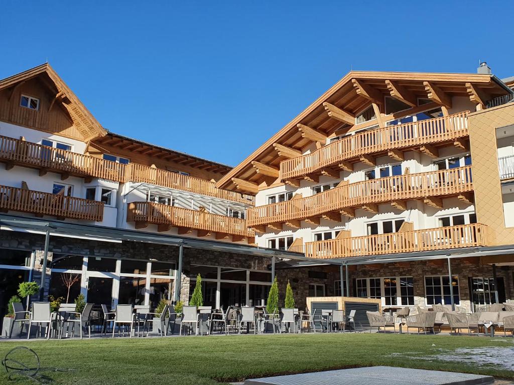 un grand bâtiment avec des tables et des chaises devant lui dans l'établissement Hotel Seespitz Seefeld Superior, à Seefeld in Tirol