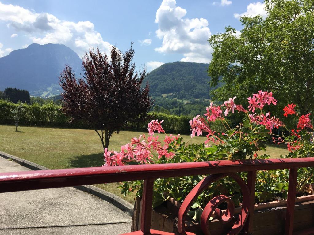 a view from the balcony of a house with pink flowers at chambres d'hôtes des Bauges ROUTE 26 57 in La Motte-en-Beauges