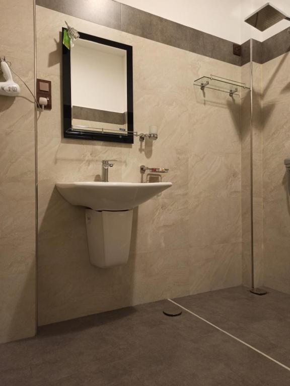 bagno con lavandino e specchio a parete di Suriya Homestay Mirissa a Mirissa
