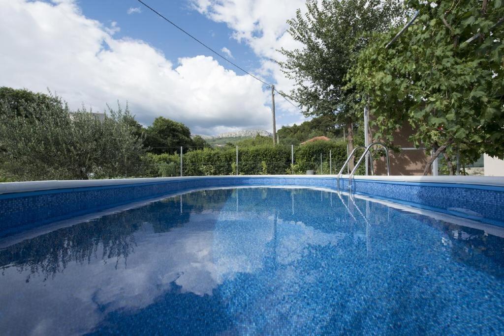 une piscine bleue avec réflexion dans l'eau dans l'établissement Holiday home Elijah Creek, à Split