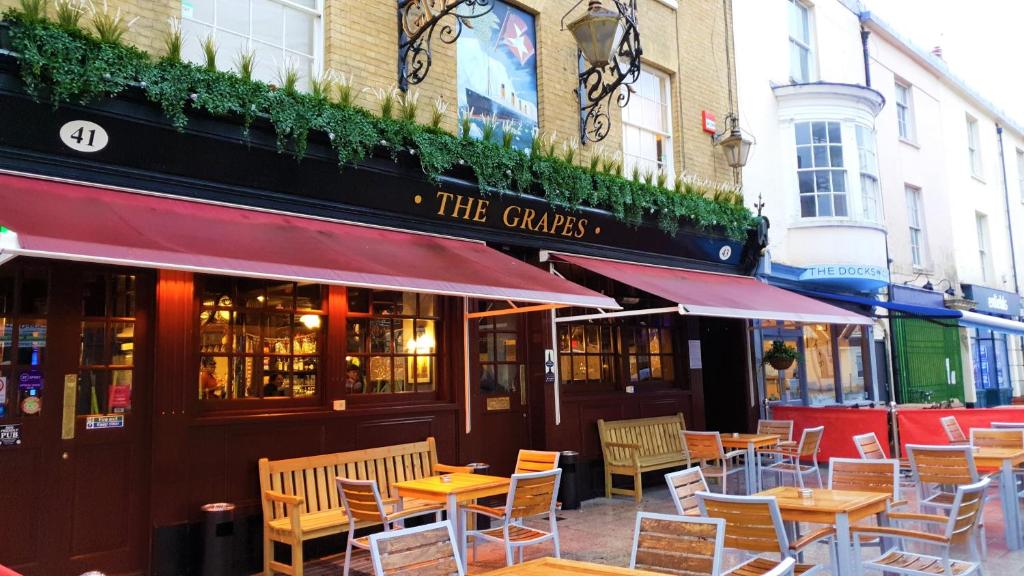 
a restaurant with tables, chairs, and umbrellas at The Grapes in Southampton
