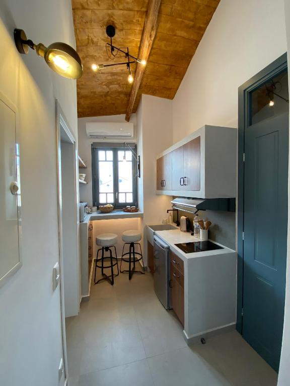 a kitchen with a sink and a counter with stools at CAMARA SUITES in Andros