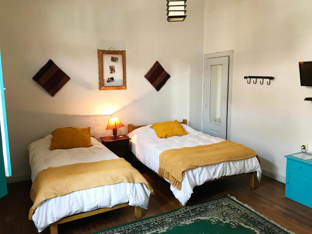 a bedroom with two beds with yellow pillows at Park Hostel in Arequipa