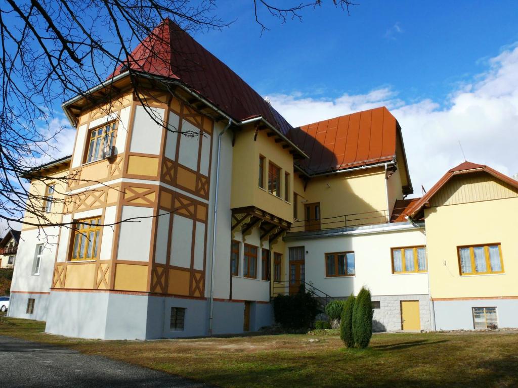 a large yellow and white building with a red roof at Apartmany PAVILON D - Budget, Classic, Family - Novy Smokovec - High Tatras in Vysoke Tatry - Novy Smokovec