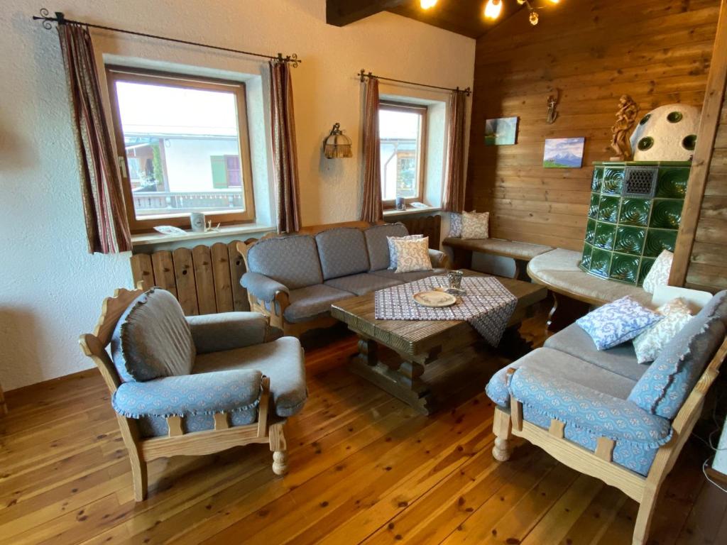 - un salon avec un canapé, des chaises et une table dans l'établissement Ferienwohnung Kehlsteinblick, à Schönau am Königssee