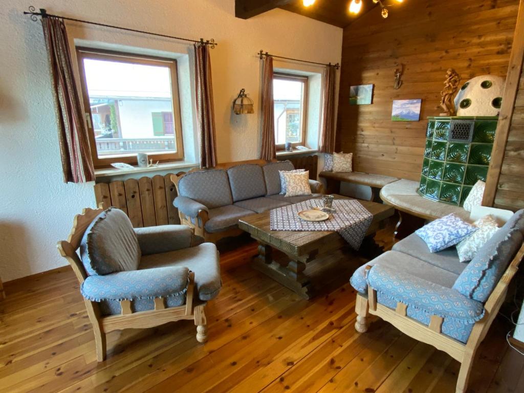 ein Wohnzimmer mit einem Sofa, Stühlen und einem Tisch in der Unterkunft Ferienwohnung Kehlsteinblick in Schönau am Königssee