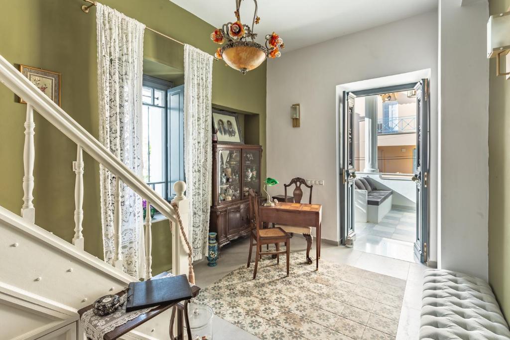 a hallway with a staircase with a table and a piano at CAMARA SUITES in Andros
