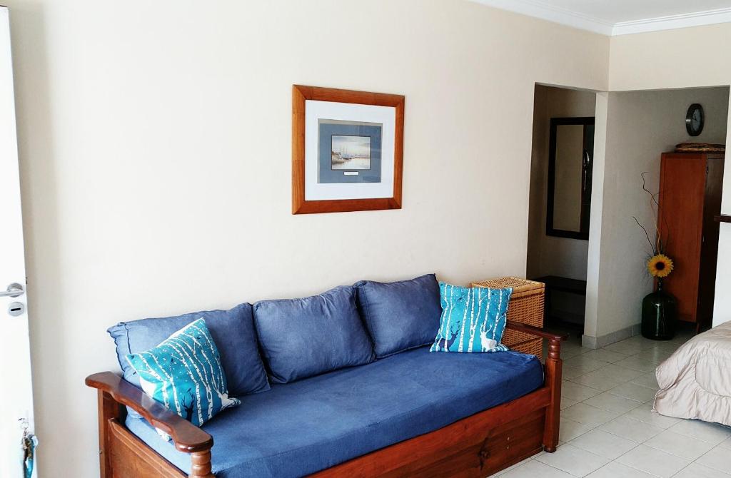 un sofá azul sentado en una sala de estar en EL REFUGIO 1 CUADRA COSTA, COCHERAS, PARRILLAS,ROPA DE CAMA,WIFI, IMPECABLE FARO MOGOTES ambiente FAMILIAR en Mar del Plata