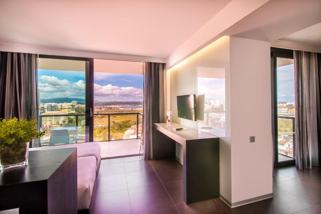 a living room with a couch and a large window at RR Hotel da Rocha in Portimão