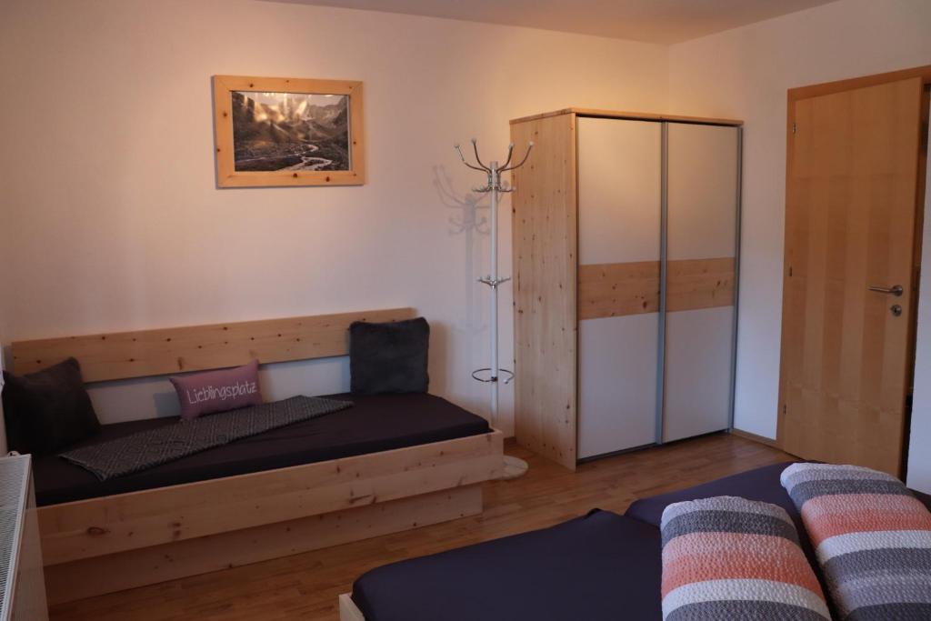 ein Wohnzimmer mit einem Bett und einem Schrank in der Unterkunft Haus Gastl in Arzl im Pitztal