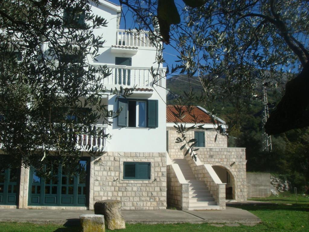 a white building with a staircase in front of it at Guest house Dragović in Sveti Stefan