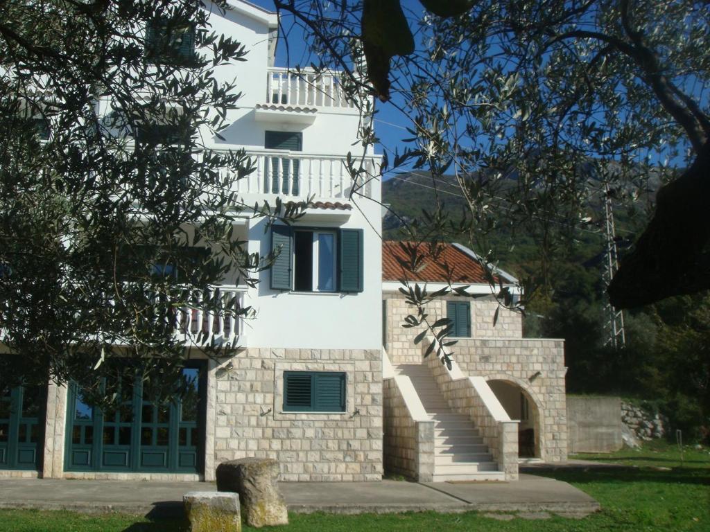 un edificio bianco con una scala di fronte di Guest house Dragović a Sveti Stefan