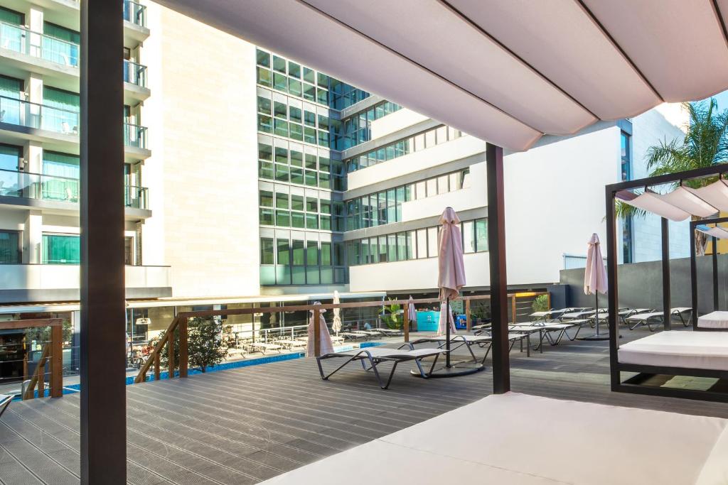 a balcony with chairs and umbrellas on a building at RR Hotel da Rocha in Portimão