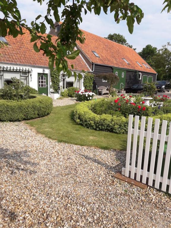 a white fence in front of a house at De Notenboom in Meliskerke