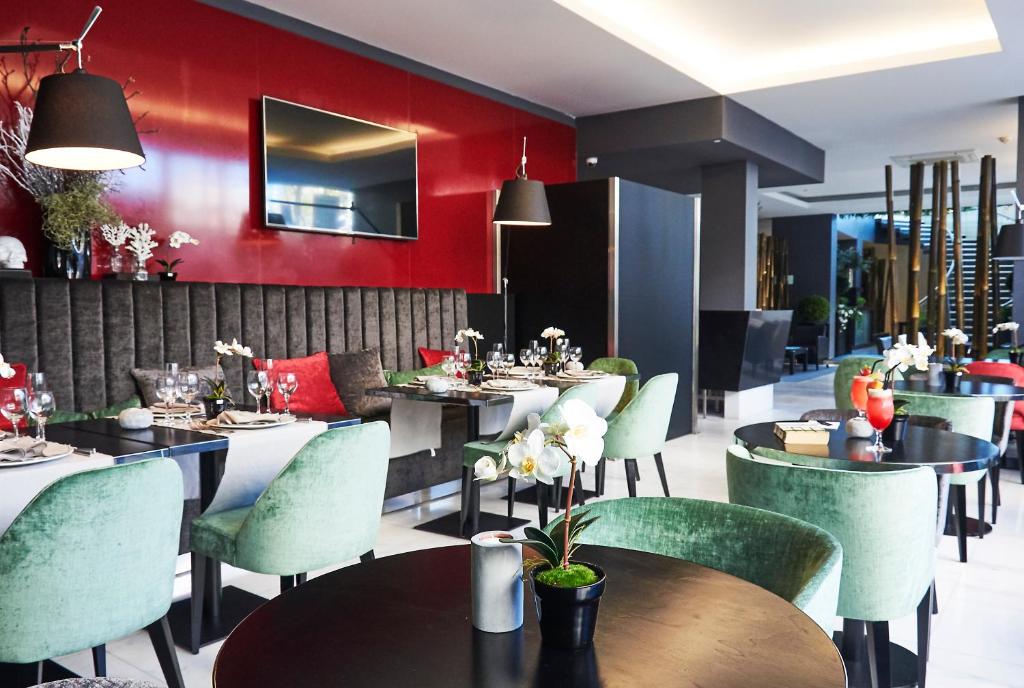 a restaurant with tables and chairs and red walls at RR Hotel da Rocha in Portimão