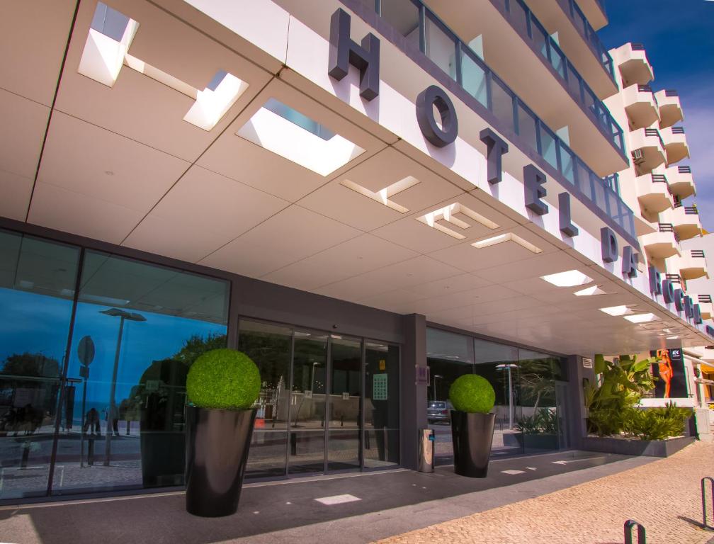 a building with potted plants in front of it at RR Hotel da Rocha in Portimão