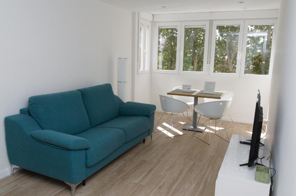 sala de estar con sofá azul y mesa en Moderno,tranquilo, entrada autónoma y fácil aparcamiento., en Madrid