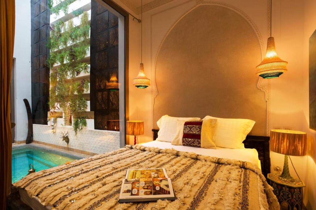 Un dormitorio con una cama con una bandeja de comida encima. en Riad Lumière, en Marrakech