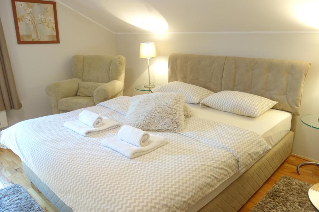 a bedroom with a bed with towels and a chair at Villa Quantum Beograd in Belgrade