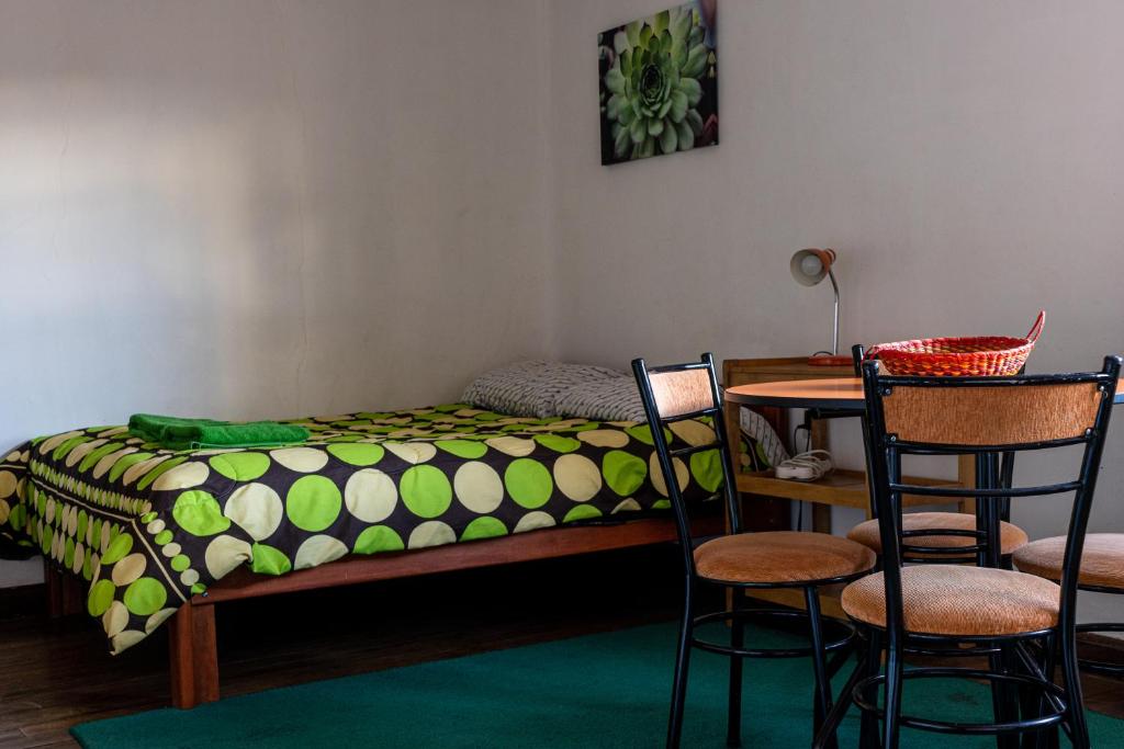 1 dormitorio con 1 cama, mesa y sillas en Nice studio in historic center with private bathroom and kitchen!, en Cusco