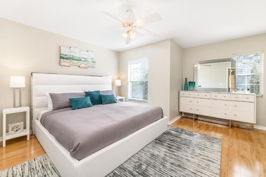1 dormitorio con cama, tocador y espejo en Lovely Disney Vacation House, en Orlando