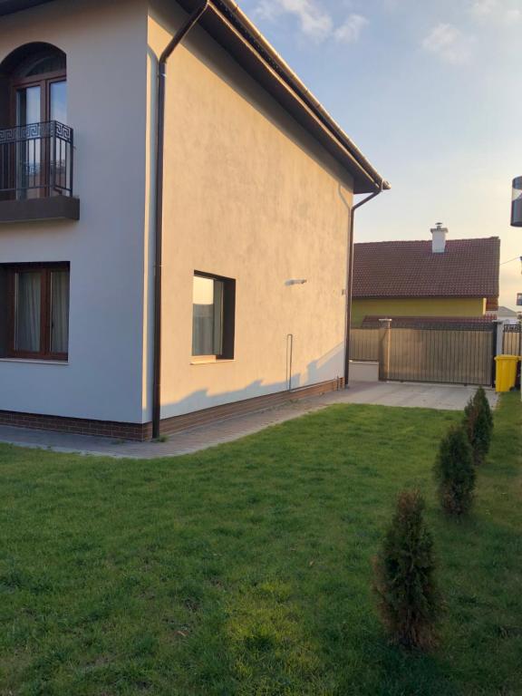 a house with a green yard in front of it at Holiday Luxury Villa with private Garden in Şelimbăr