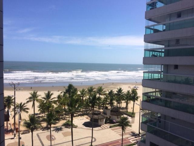 widok na plażę z palmami i budynek w obiekcie Praia Grande Frente ao Mar-Albatroz w mieście Praia Grande