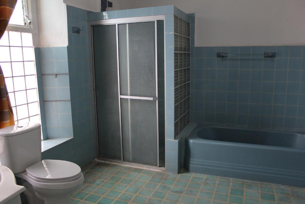 Un baño con bañera azul y un inodoro. en Hostal VELVET PLAZA, en Santa Ana