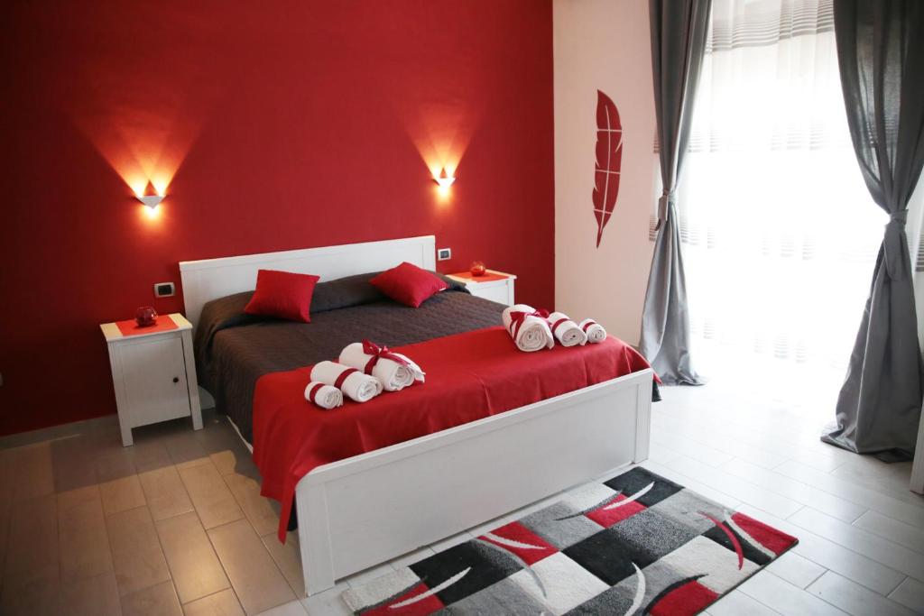 Schlafzimmer mit einem Bett mit roten Wänden und roter Bettwäsche in der Unterkunft B&B Magma in Ercolano