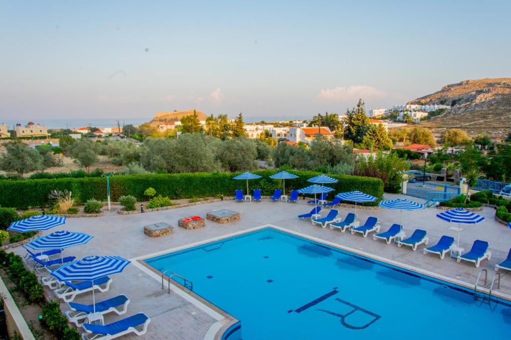 uma vista para uma piscina com cadeiras e guarda-sóis em Rafael Hotel-Adults Only em Lindos