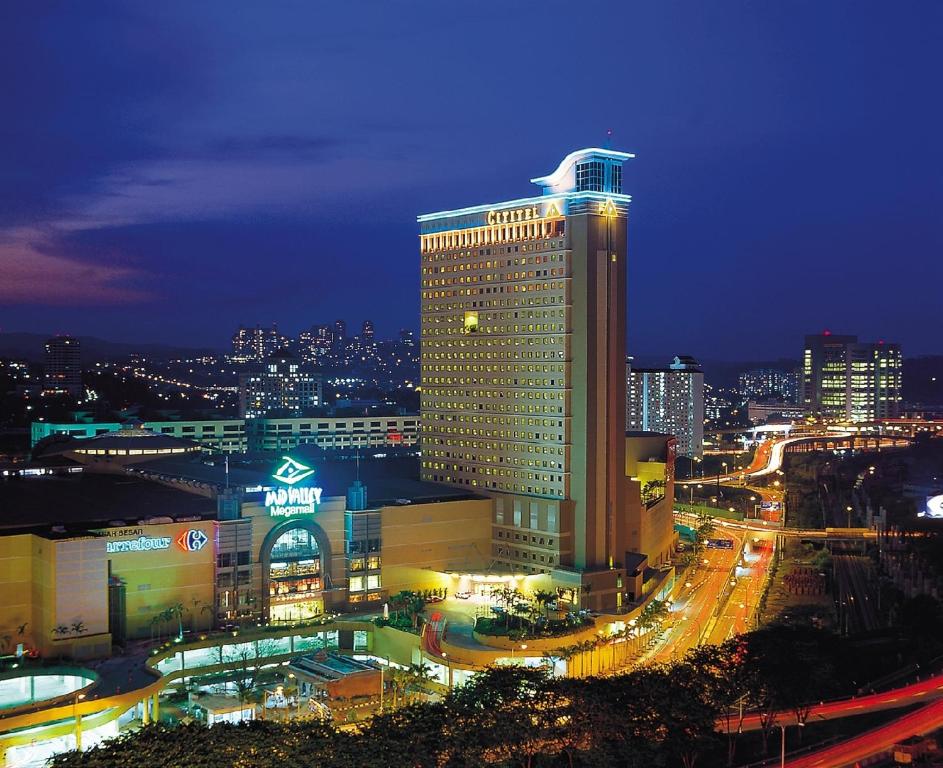 un edificio illuminato con una città di notte di Cititel Mid Valley a Kuala Lumpur