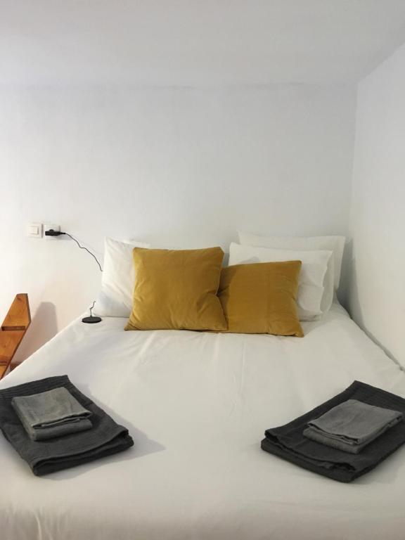 a white bed with two black towels on it at Cathedral Studio in Las Palmas de Gran Canaria