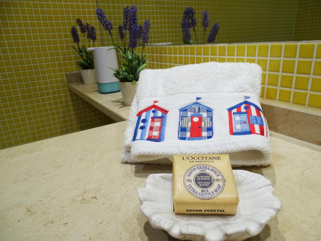 a group of towels sitting on a counter with a box at Cantinho do Sol - Sea view, Quiet, Cozy and Relaxing Flat in Armação de Pêra