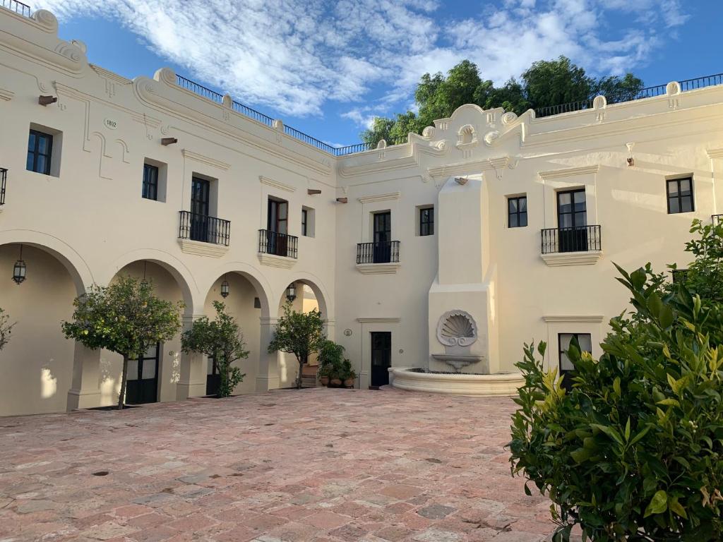 a large white building with a courtyard at Mesón de la Merced Hotel Boutique Patio & Spa in Querétaro