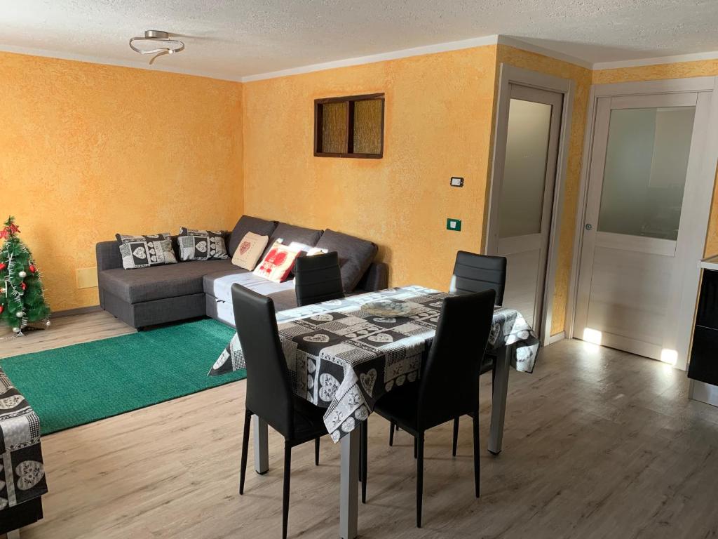 ein Wohnzimmer mit einem Tisch und einem Sofa in der Unterkunft Lo Miete de René in La Thuile