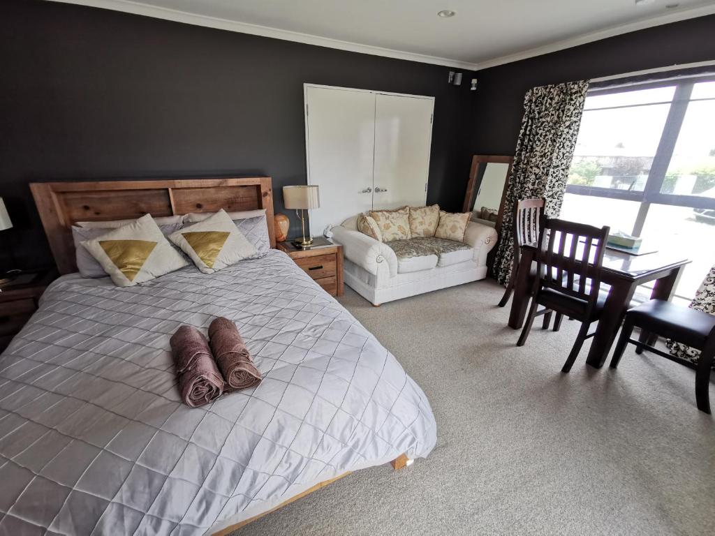 a bedroom with a bed and a living room at Lakeview Holiday Hideaway in Taupo