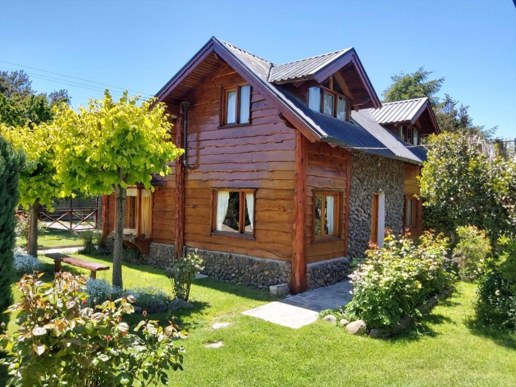 una casa de madera con un jardín delante de ella en El Aguila en San Carlos de Bariloche