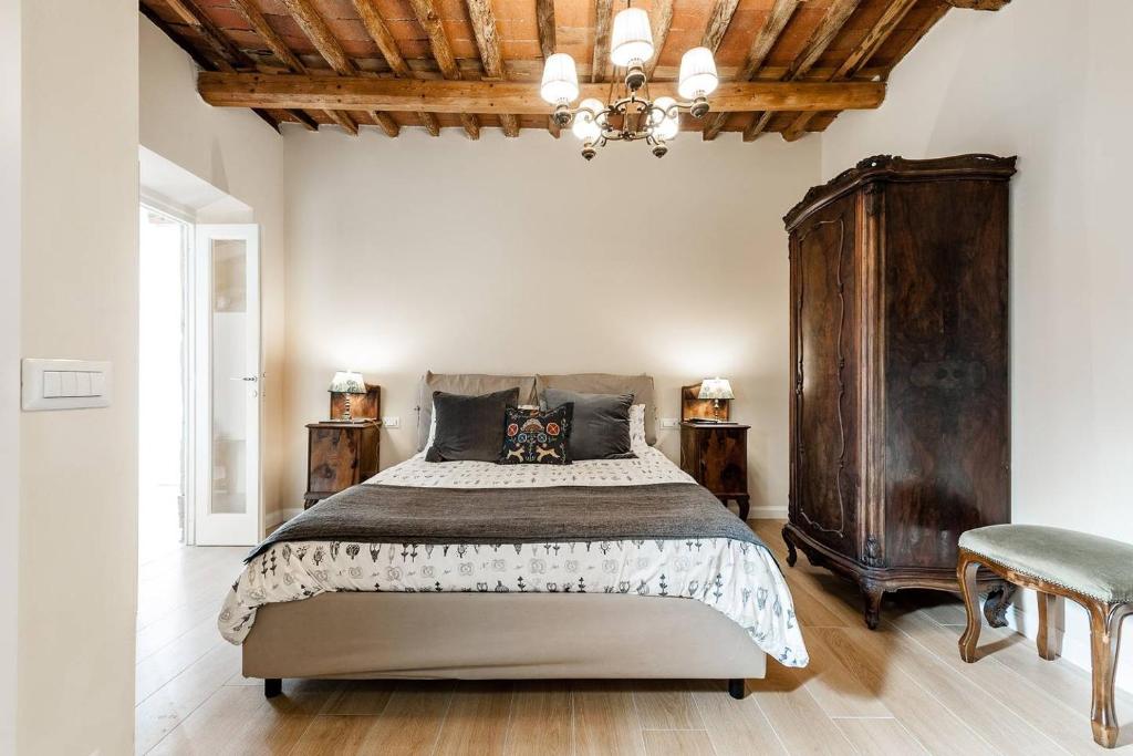 1 dormitorio con 1 cama grande y techo de madera en Cortile in centro - Charm Suite Heart of Lucca, en Lucca
